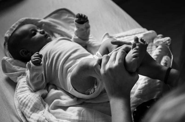 a baby is in his mother's lap while holding it up