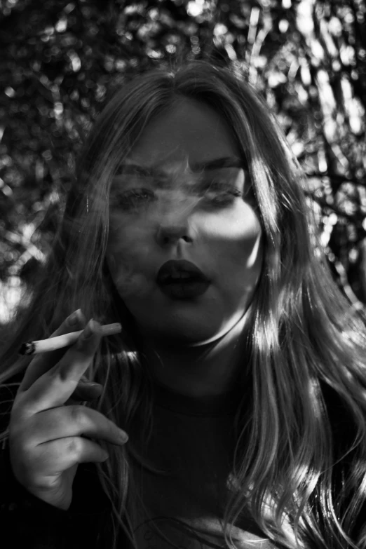 woman smoking a cigarette in a dark forest
