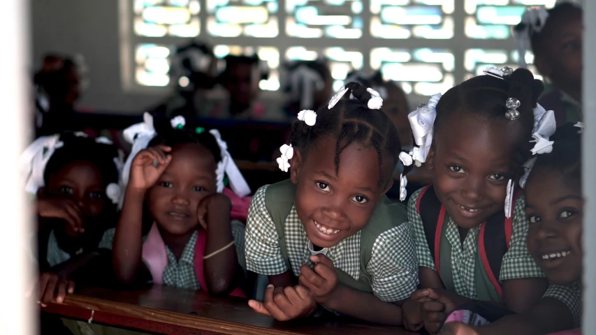 four children are sitting in a row smiling