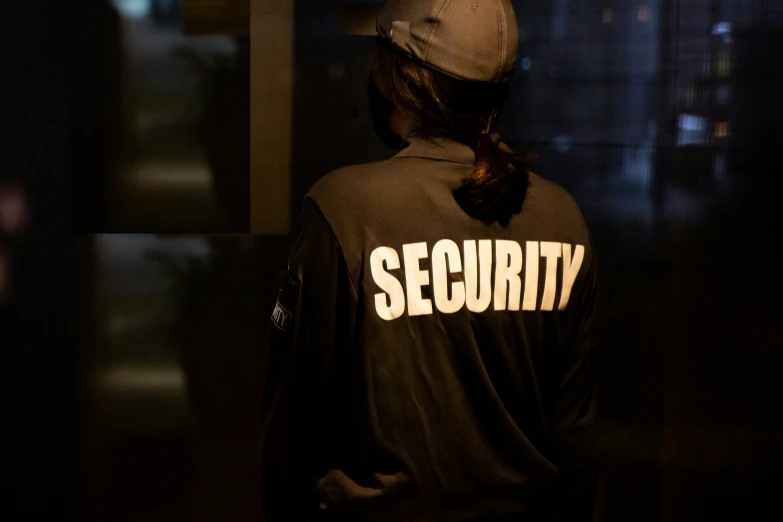 a security shirt adorns a window while someone walks down a dark street