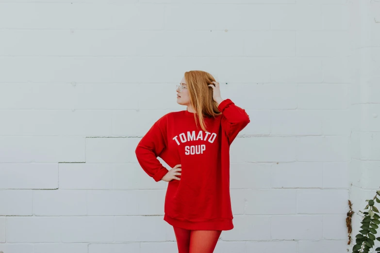 a girl in a red sweater looks off to the side