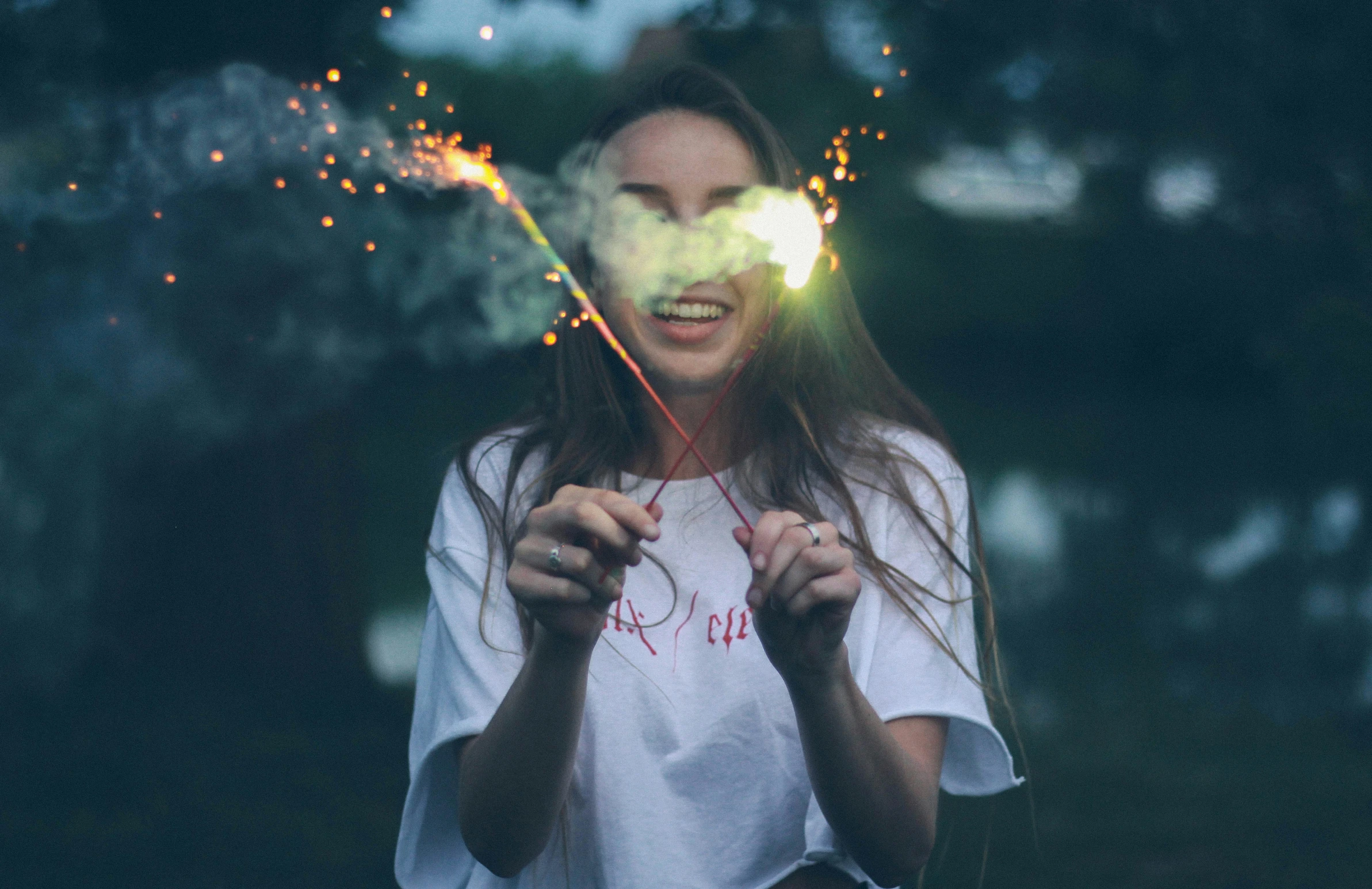 the woman is smiling as she sparkles with sparklers