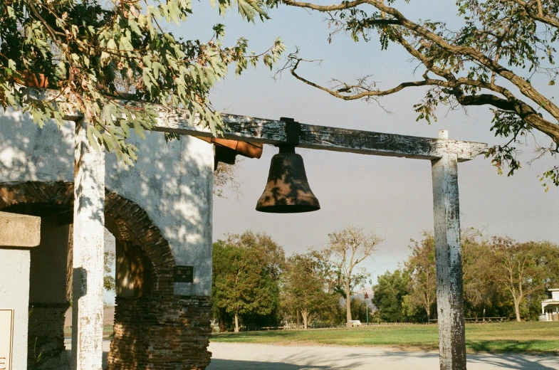 a bells is hanging over the top of a building