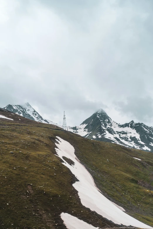 snow - covered green hills and alpine mountains with trees