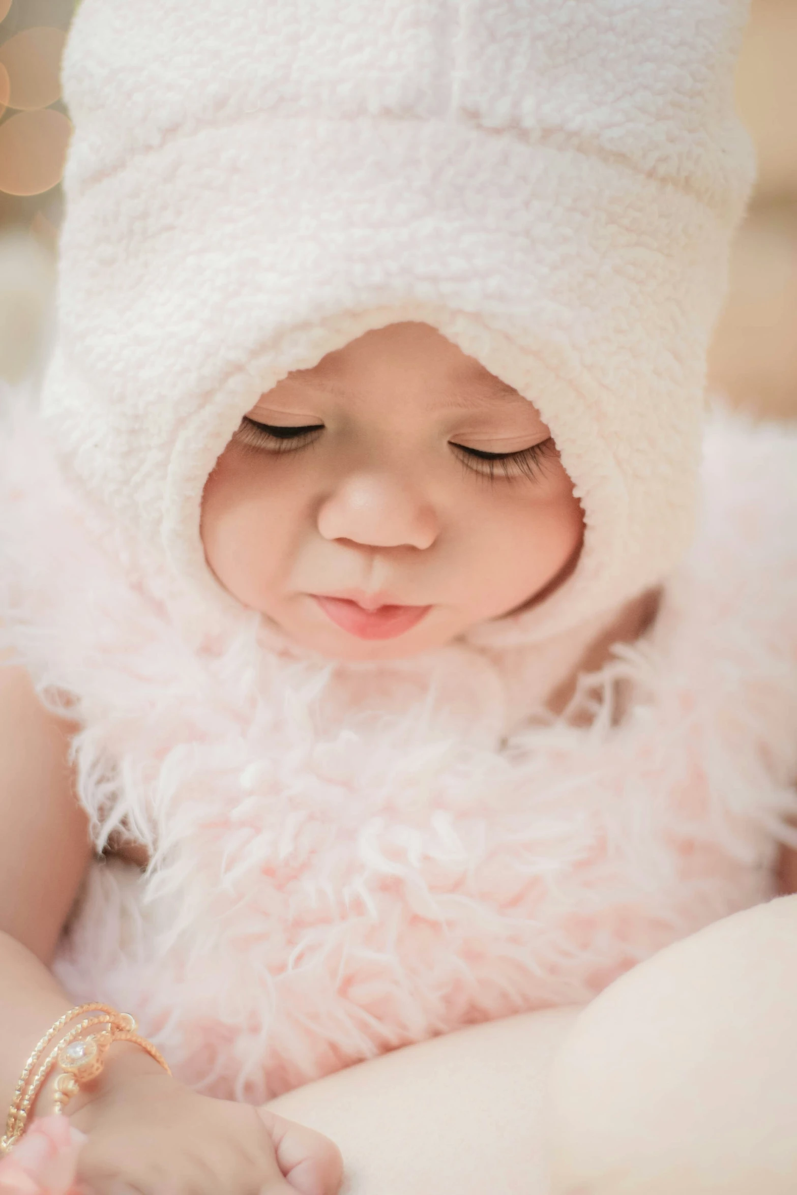 a baby is wearing a fluffy white hat