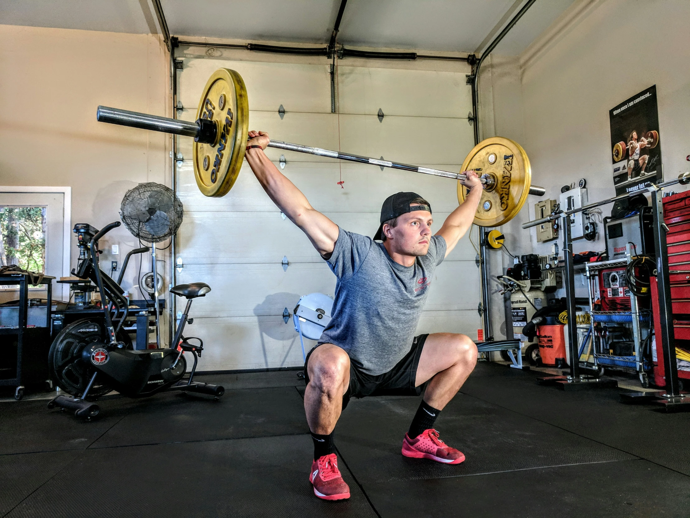 a person in a gym holding two barbells