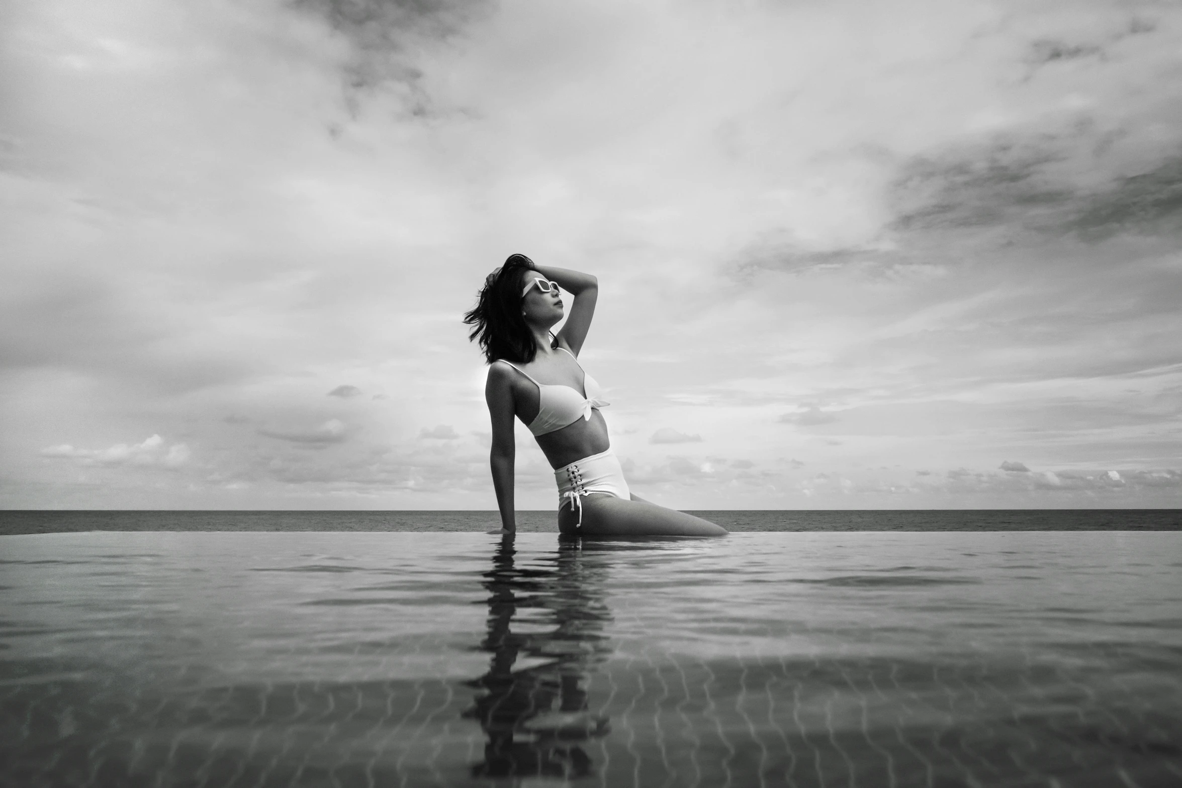 a woman with her hands behind her back in the water