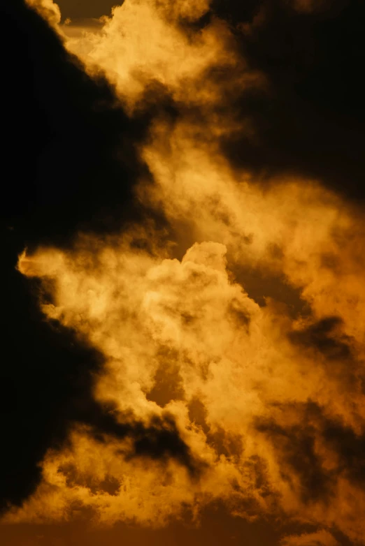 a jetliner flying through a cloudy sunset sky