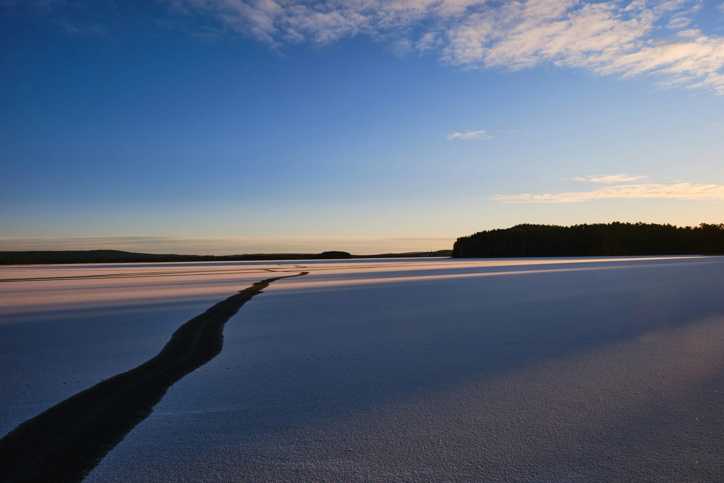 the blue sky over a frozen beach with some clouds