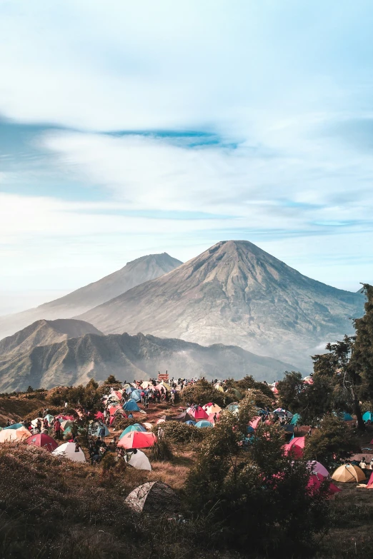 a group of tents set up in the woods in front of mountain