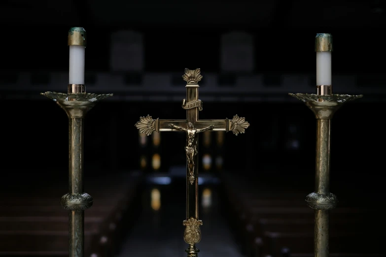 three candle candles with ornate decorations and a cross in the center