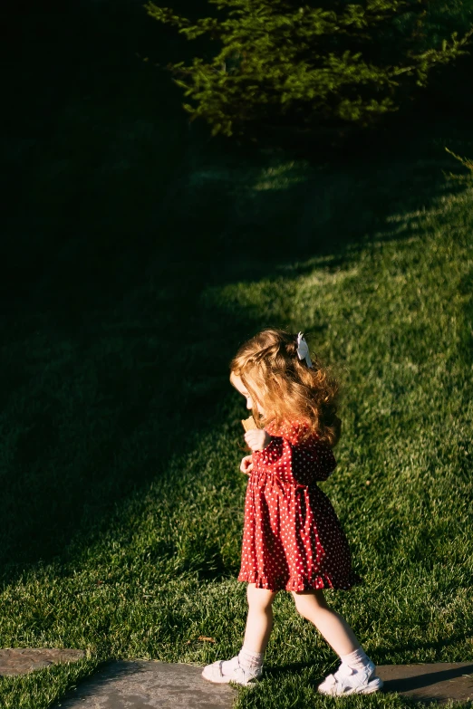  in red polka dot dress holding a black frisbee