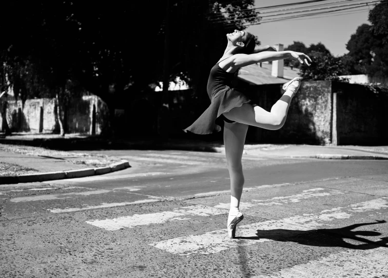 a young dancer performs on the road on the sunny day