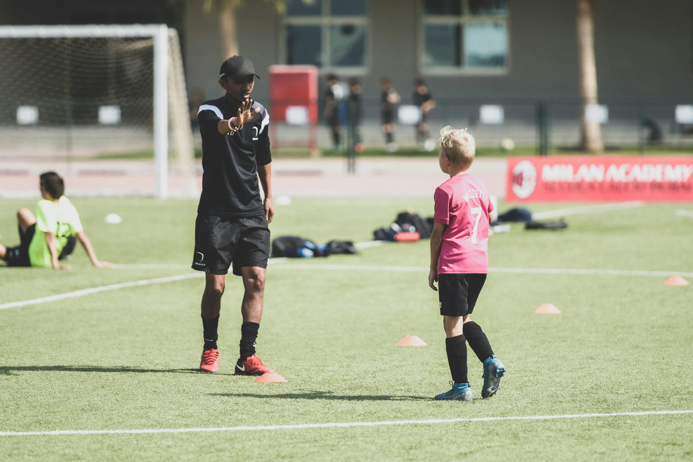 two boys are talking on a soccer field