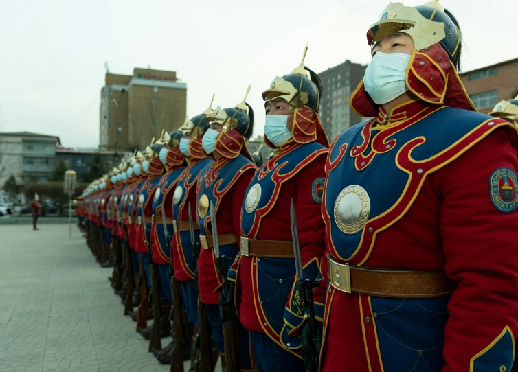 guards in uniform standing side by side with masks on