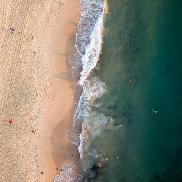 aerial view of beach scene with white waves and people