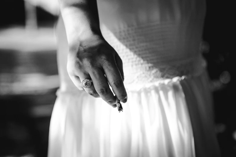 a close up of a person holding a wedding ring