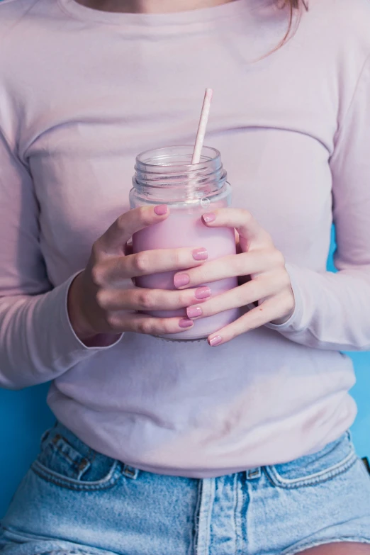 a women holding a drink and a straw in her hands