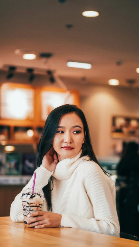 woman with coffee smiling at the camera while holding a bag