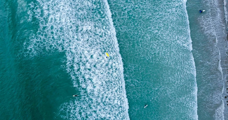 the top down view of an ocean with surfers