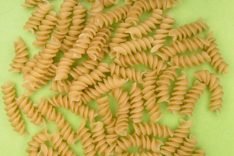 a closeup of pasta shells on green table cloth
