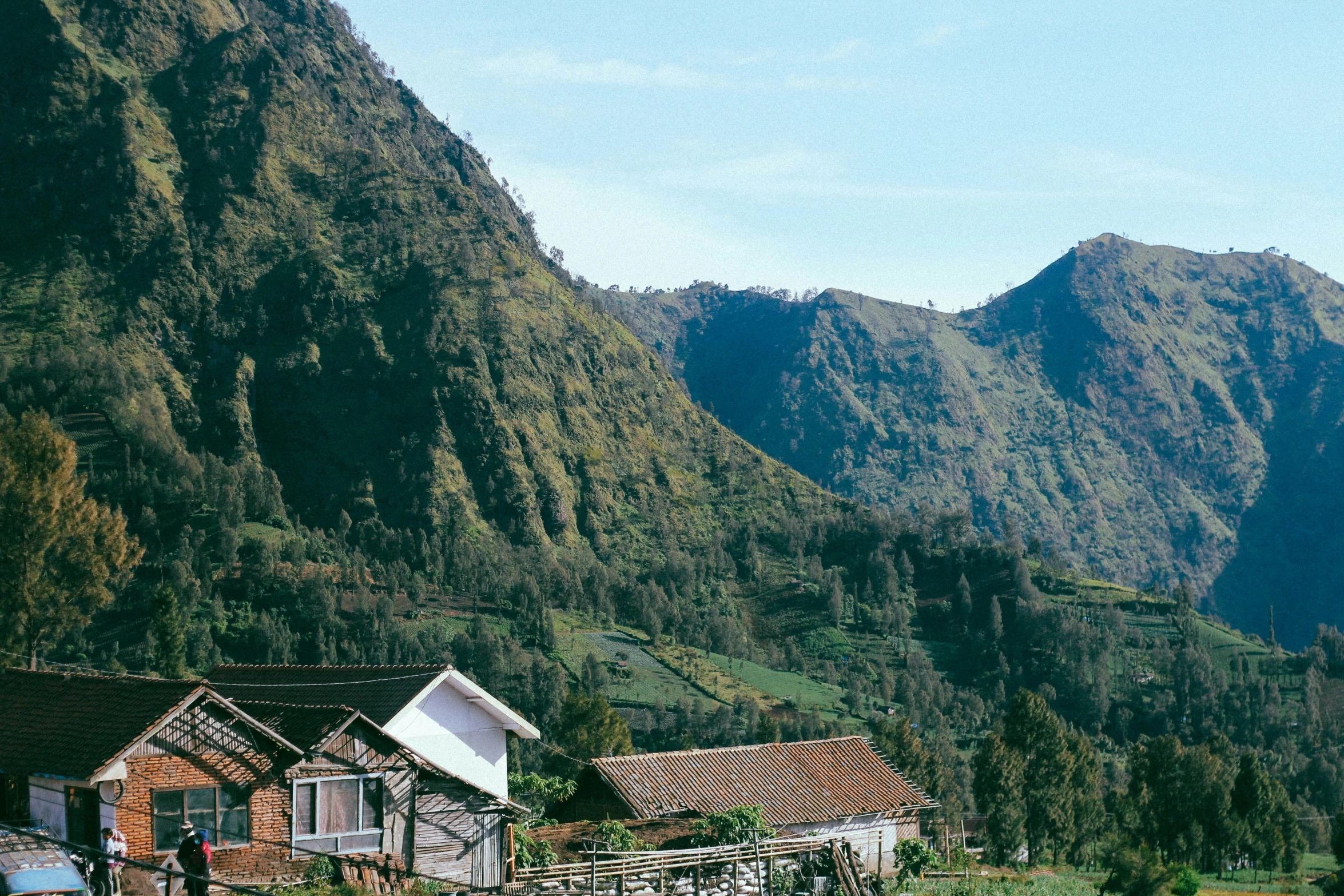 a few houses near the side of a mountains