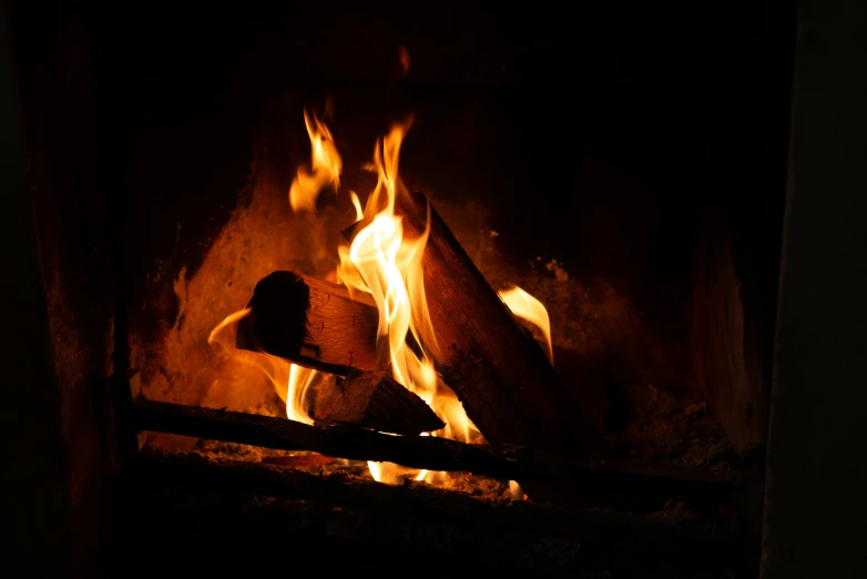 a fireplace with wood and fire as it consumes