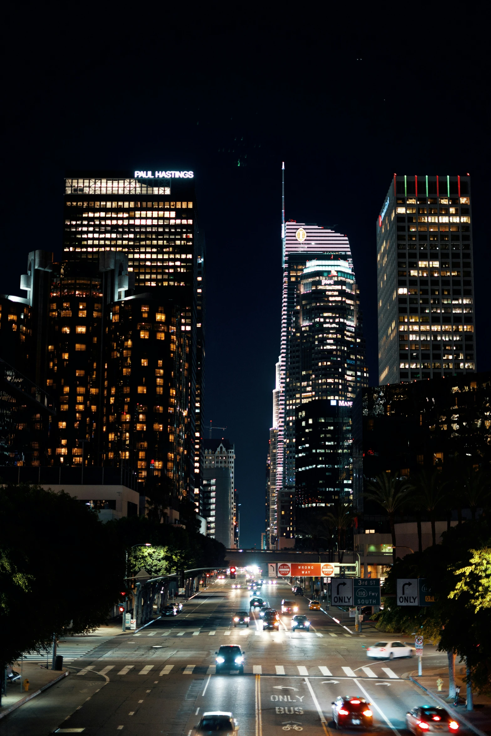 view of skyscrs and cars in city at night