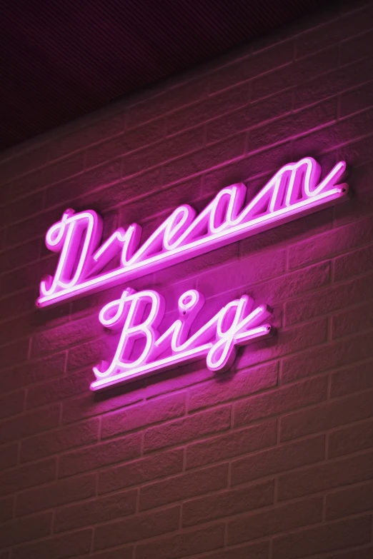 a neon sign that reads dreams big