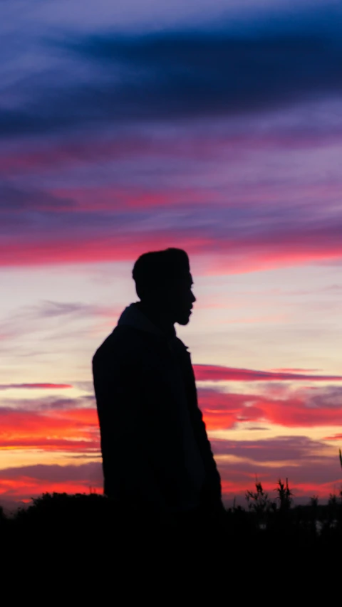 a person looks up at the sky with an orange glow