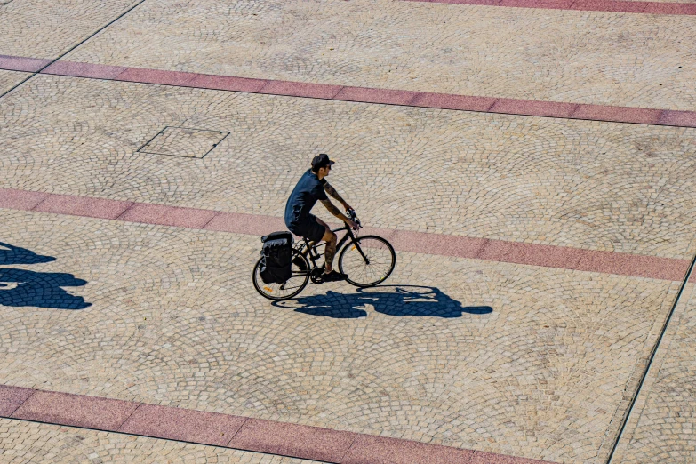 two people riding bikes on pavement in the daytime