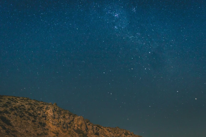 a mountain at night with the milky in the sky