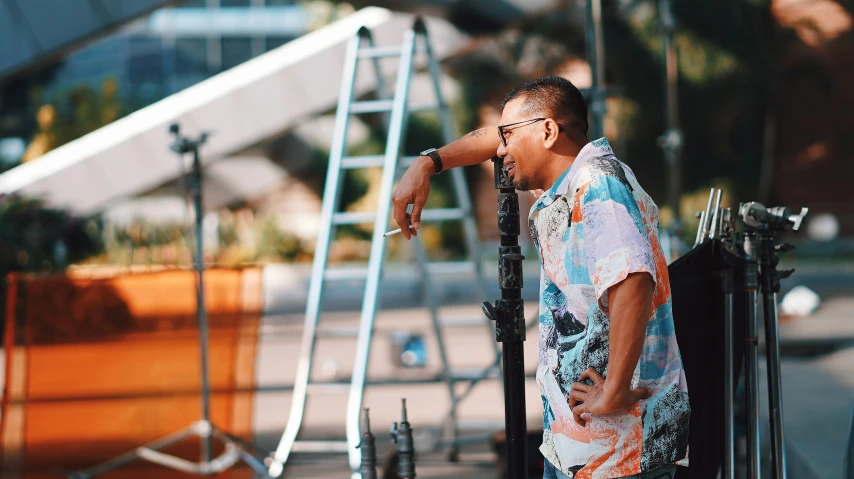 a man with sunglasses on standing next to several large objects