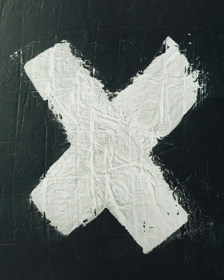 an x painted on a black wall