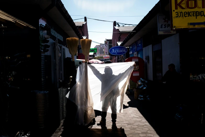 a man holding a cloth in the middle of an alleyway