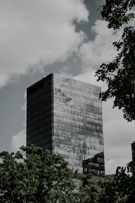 a building with trees around it that is covered by clouds