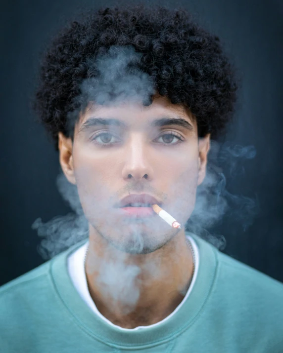 a man in green shirt smoking a cigarette