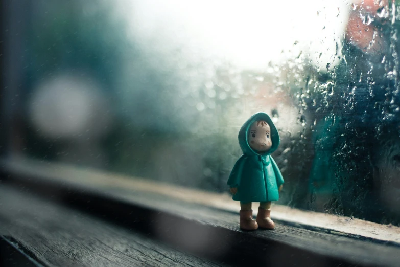 the doll is standing in the rain looking out the window