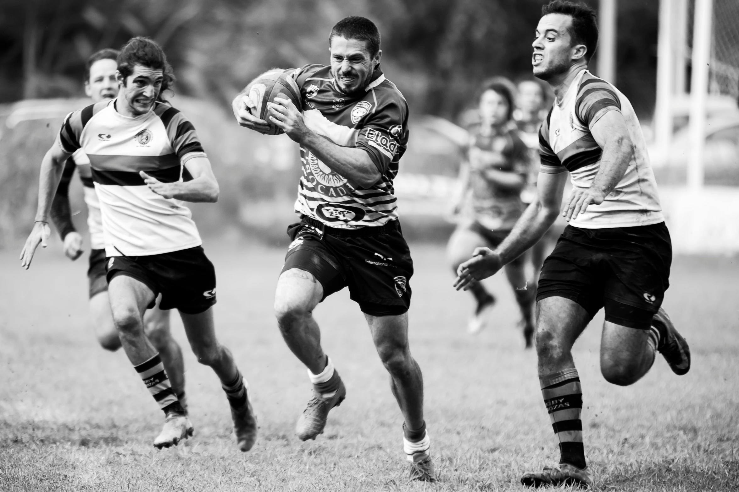 four men running towards each other on a field