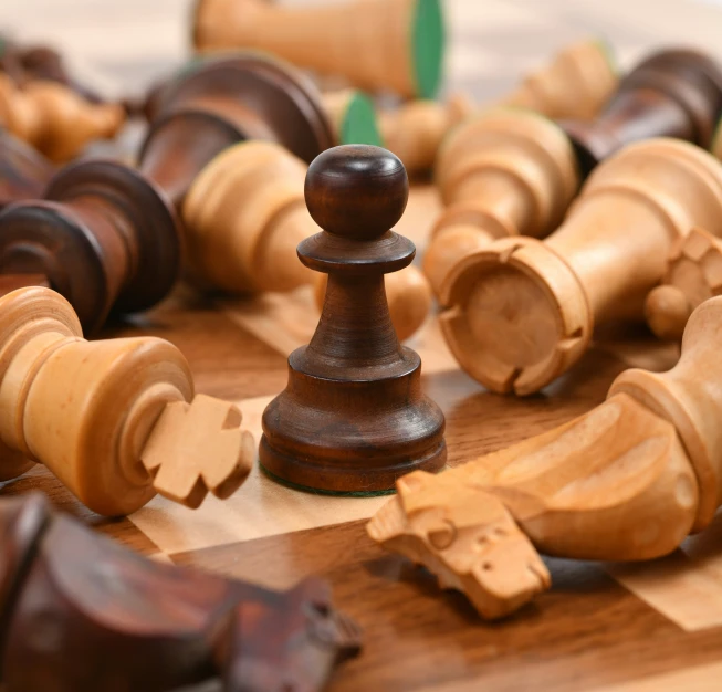 chess pieces on wooden table, all being made up of various sizes and finishes