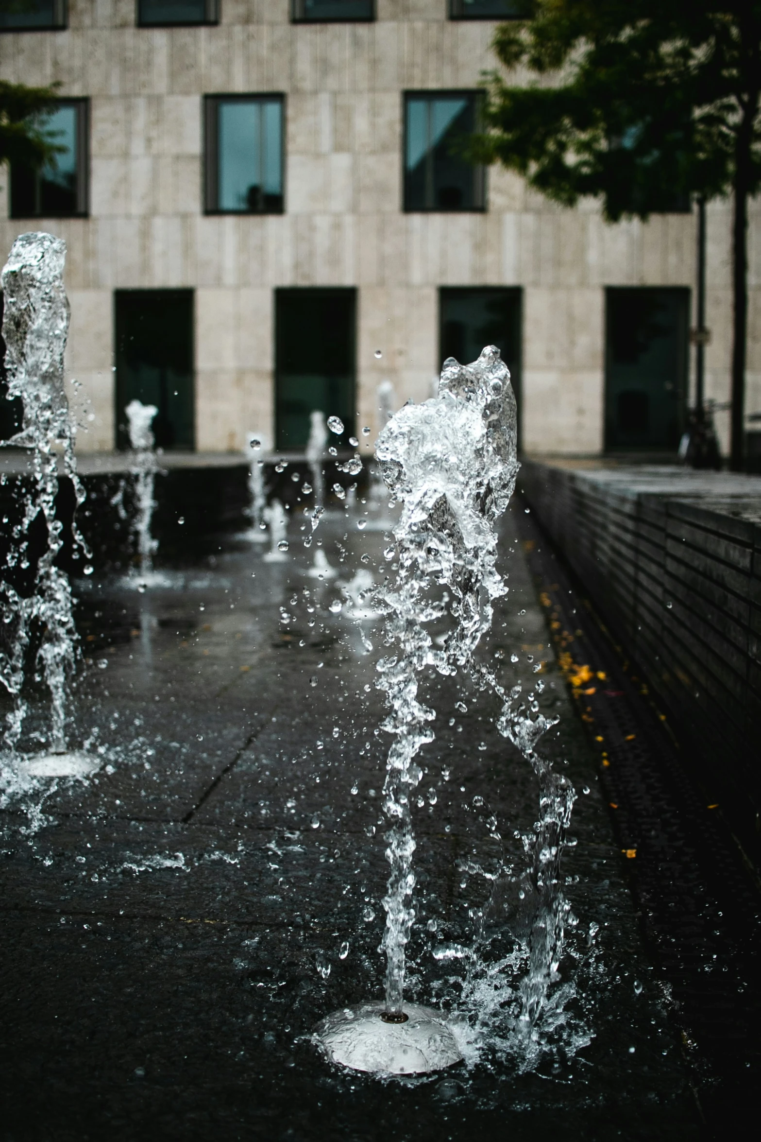 two water fountains next to each other in the rain