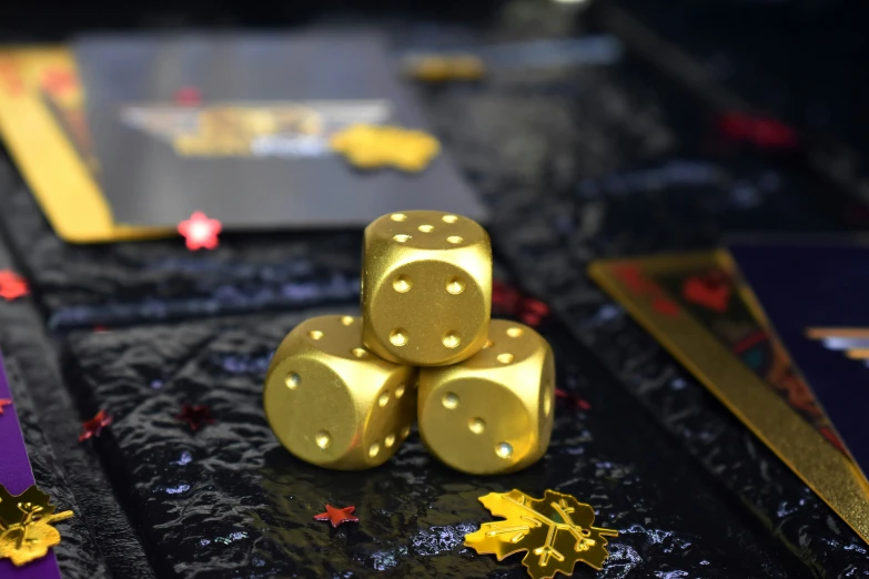 four gold dices sit atop a black cloth
