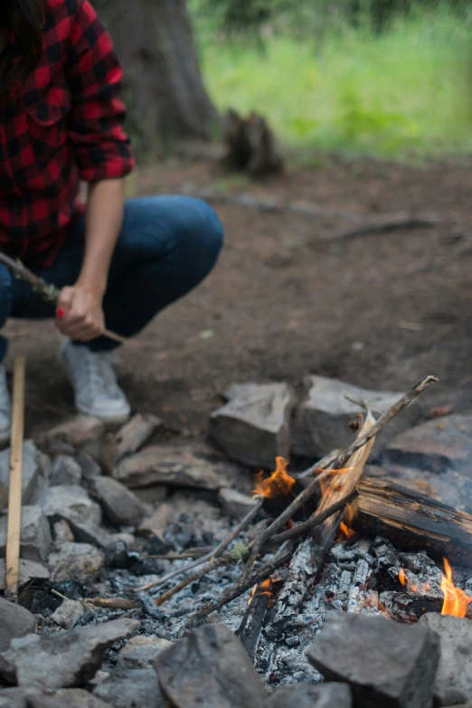 a person stirring soing with sticks over a fire