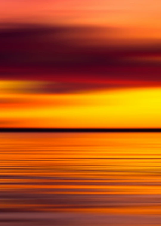 the ocean is calm and colorful at sunset