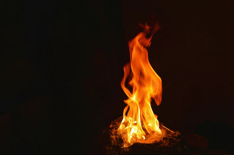 a fire burning in the fireplace next to a wall