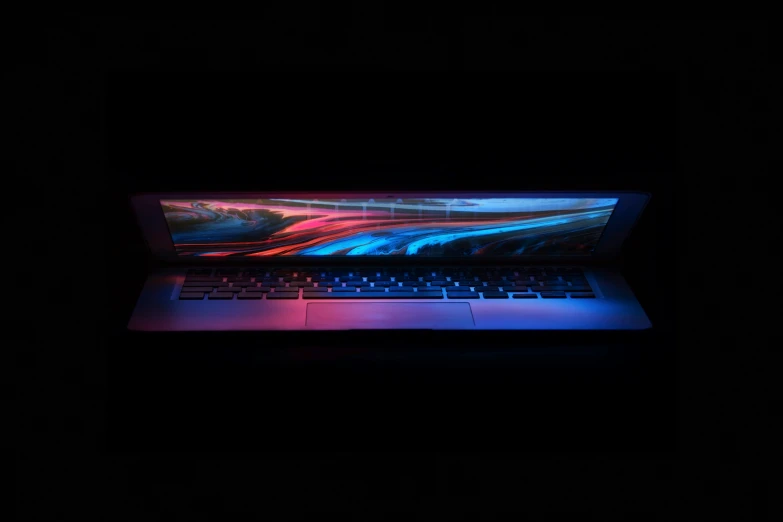 a laptop computer on display in a dark room