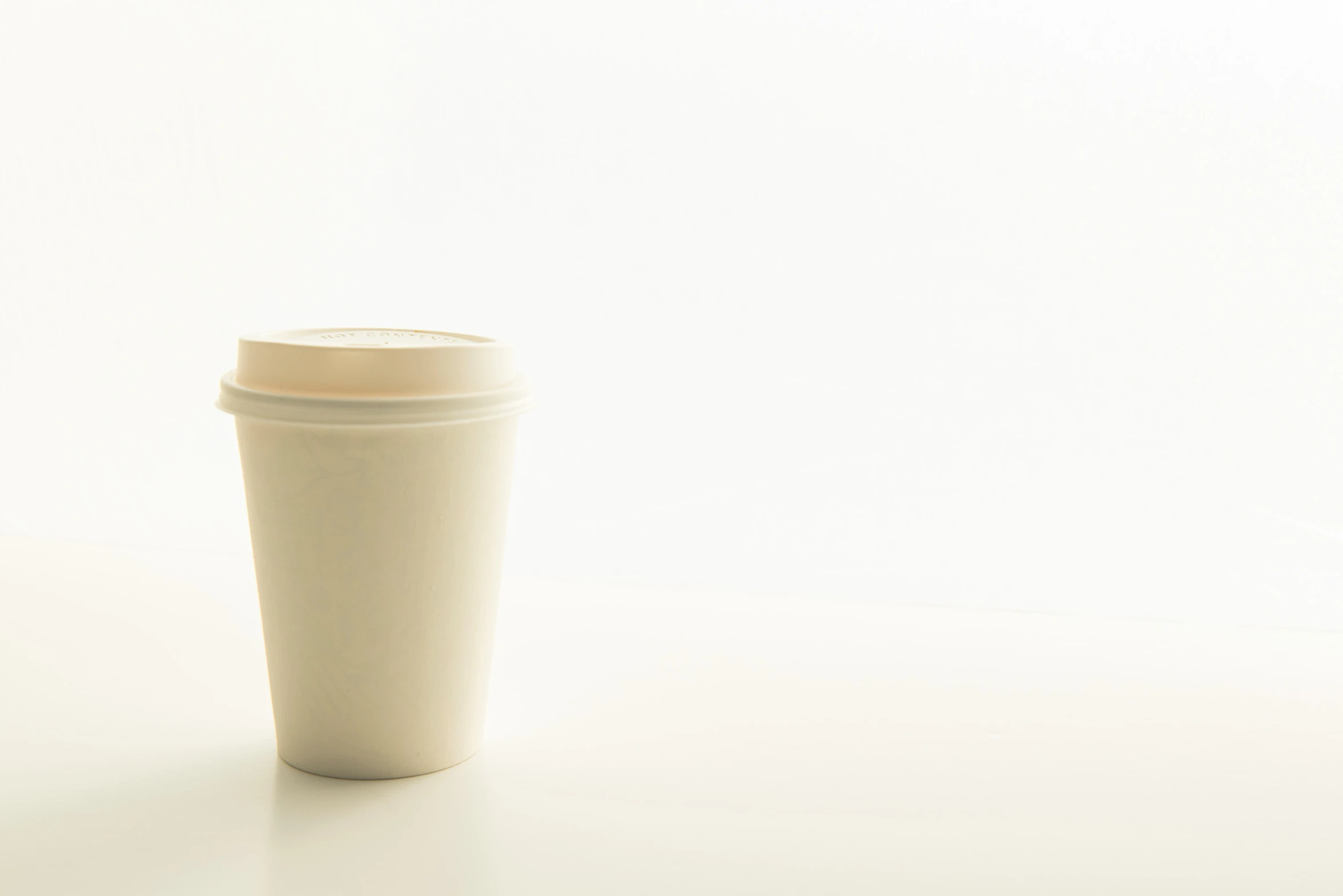 coffee cup sitting on top of a white surface