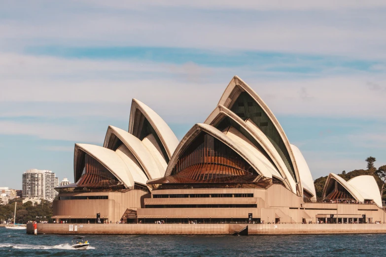 there is a paddle boat in the water next to a large opera