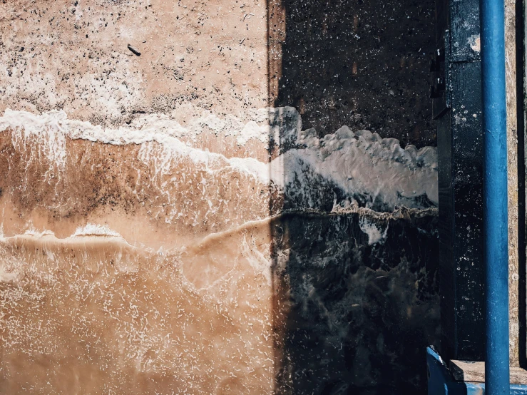 the wall has a water feature and there is a blue pole on the right side