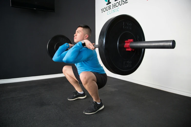 a man is squatting in a gym